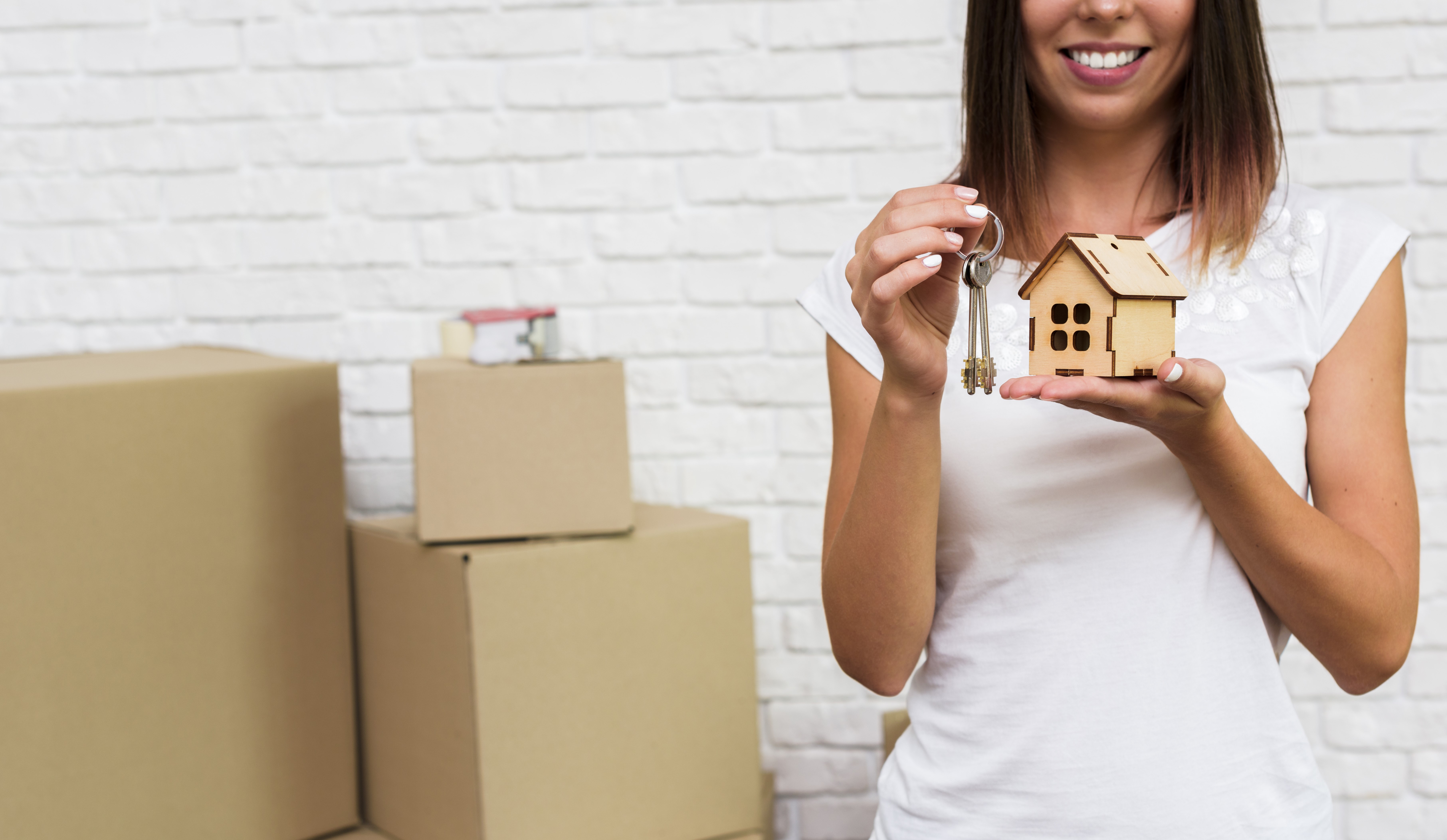 smiley-woman-holding-wooden-cottage-keys.jpg?Revision=d9M&Timestamp=skkYlk